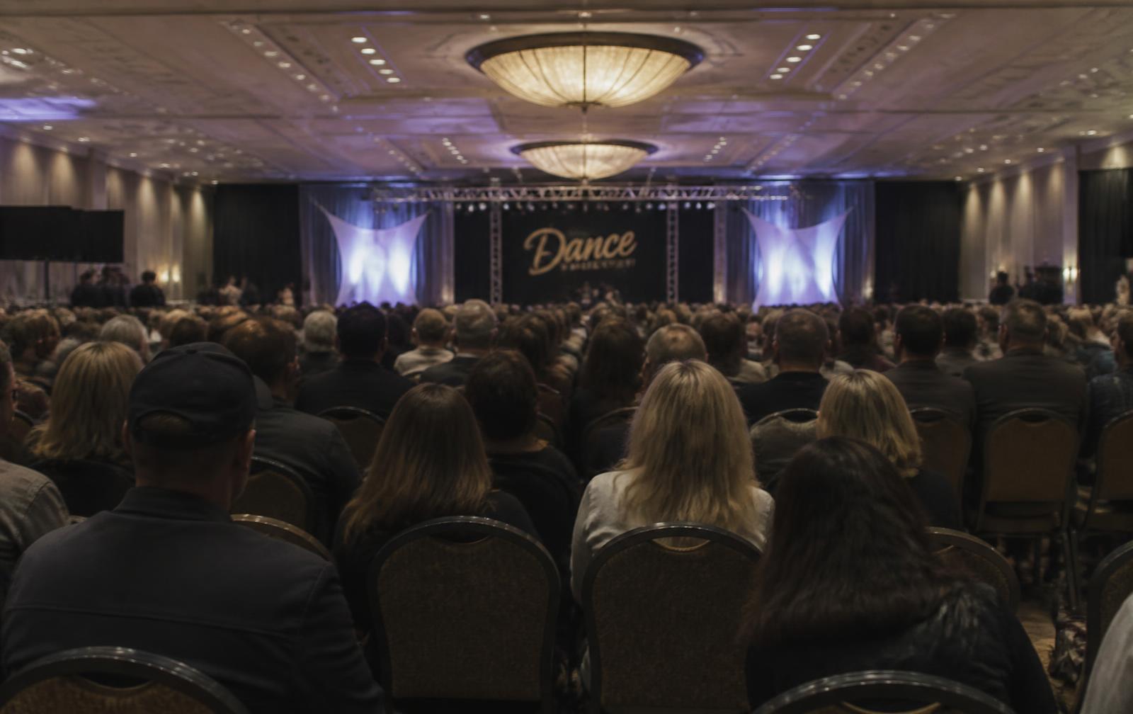 Parents seated in a hotel ballroom audience during a dance convention weekend